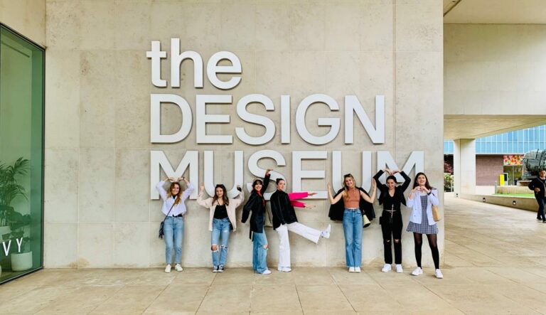 A group of students stands in front of a sign reading "the design museum."