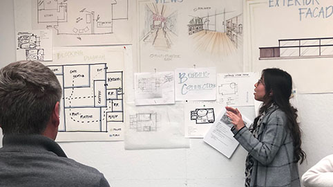 a group of people in front of a wall with drawings on it