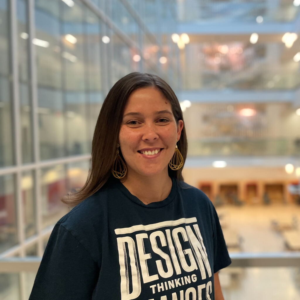 A woman in a black T-Shirt that says "Design"