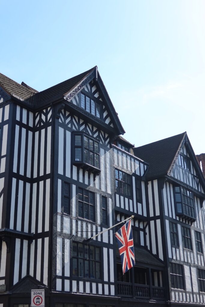 A tudor style building flying a British flag
