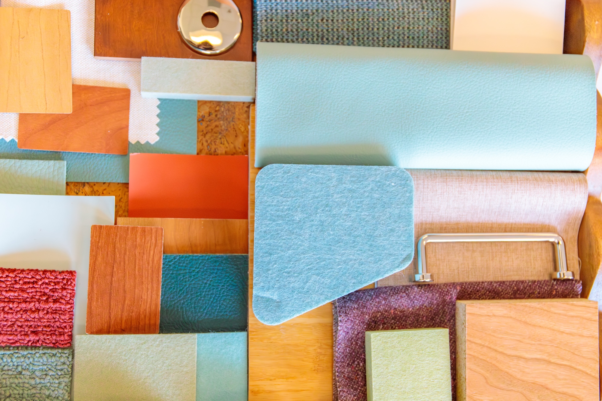 A colorful flatlay of paint chips, building materials, and other samples