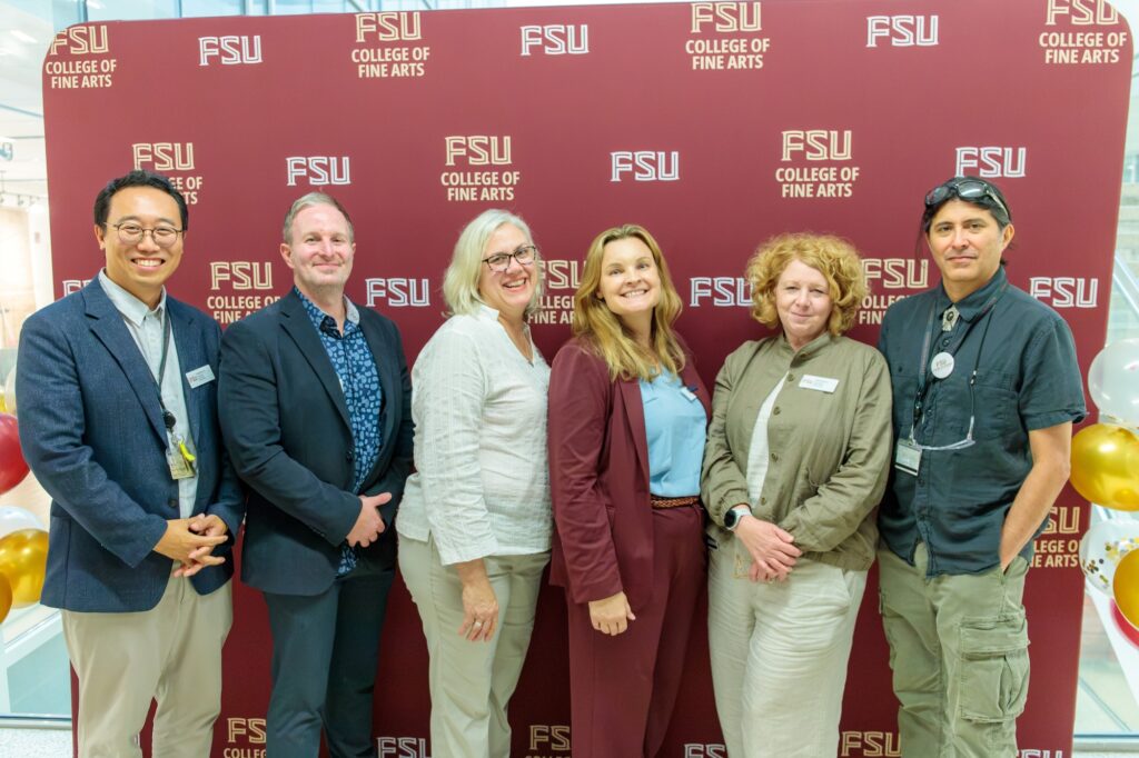 A group of professionals pose for a photo in front of a garnet backdrop that says "FSU"